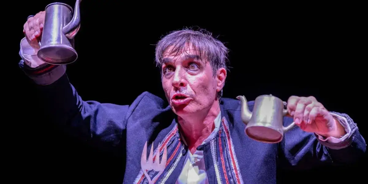 Sebastián Pajoni en escena en «Pequeño William», con una jarra de metal en cada mano